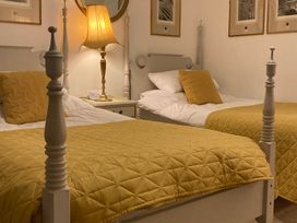 A bedroom with two beds and a lamp at Groves Hall Garden Apartment Whitby