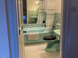 A bathroom with a bath tub and toilet at Groves Hall Garden Apartment Whitby
