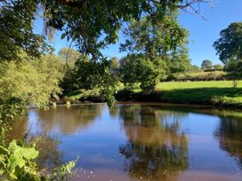 A river with trees and grass at Groves Hall Garden Apartment Whitby