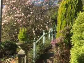 A garden with a flowering tree and a pathway at Groves Hall Garden Apartment Whitby