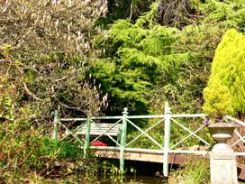 A bridge and bench in a garden at Groves Hall Garden Apartment Whitby
