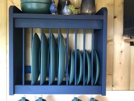 Shelves displaying plates and mugs at The Peacock Shepherds Hut at Hafoty Boeth, Corwen