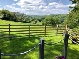 An outdoor area with a fence and a view of trees and mountains at The Peacock Shepherds Hut at Hafoty Boeth, Corwen