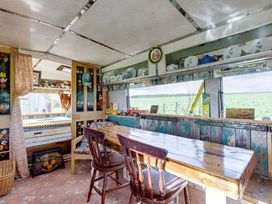 A kitchen with a wooden table and chairs at 2 x Double Bed Glamping Wagon at Dalby Forest, Scarborough