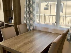 A dining room with a table and chairs at Static Caravan Mallard Rise 22 Hoburne Devon Bay in Paignton