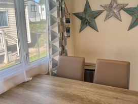 A dining room with a table and chairs at Static Caravan Mallard Rise 22 Hoburne Devon Bay in Paignton