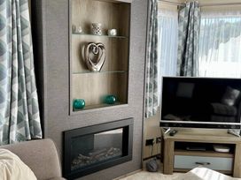 A living room with a fireplace and television at Static Caravan Mallard Rise 22 Hoburne Devon Bay, Paignton