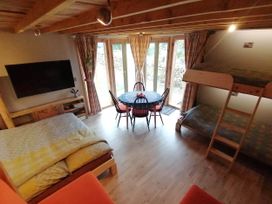 A living room with a bed and a dining table at Stone Moor Lodge, Justin's Peak District Base Camp, Sheffield