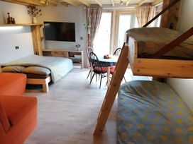 A studio with a bed, bunk bed, table, and television at Stone Moor Lodge, Justin's Peak District Base Camp Sheffield