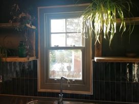 A kitchen with a window, sink, and shelves at Stone Moor Lodge, Justin's Peak District Base Camp, Sheffield