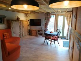A living room with a sofa, table and chairs at Stone Moor Lodge, Justin's Peak District Base Camp in Sheffield