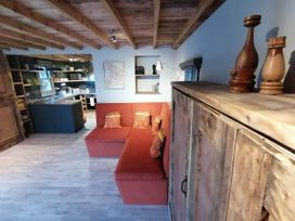 A living room with a sofa and wooden cabinet at Stone Moor Lodge, Justin's Peak District Base Camp, Sheffield