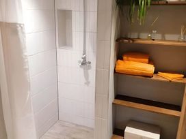 A shower with a shelf holding towels and a plant at Stone Moor Lodge, Justin's Peak District Base Camp in Sheffield