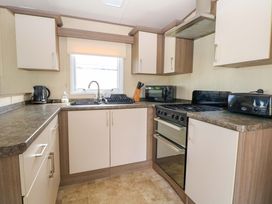 A kitchen with cabinets, sink, and appliances at PK Sunset View in Corton