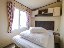 A bedroom with a bed and curtains at PK Sunset View in Corton