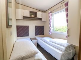 A bedroom with two beds and a shelf at PK Sunset View in Corton