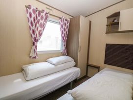 A bedroom with two beds and a wardrobe at PK Sunset View in Corton