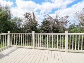 A deck with a railing overlooking trees at PK Sunset View in Corton