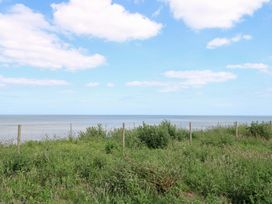 A coastal view of the sea and grass at PK Sunset View in Corton