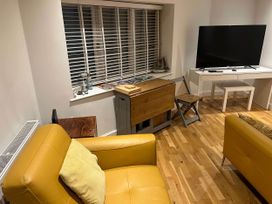 A living room with a sofa, chair, and television at Seaside Cottage Escape in Paignton