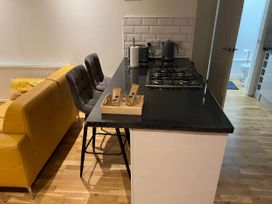 A kitchen with counter and stools at Seaside Cottage Escape in Paignton