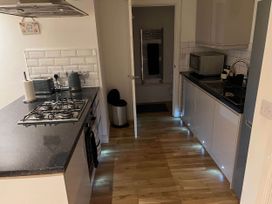 A kitchen with appliances and cabinets at Seaside Cottage Escape in Paignton