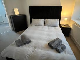 A bedroom with a bed and towels at Seaside Cottage Escape in Paignton