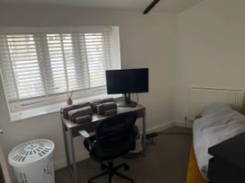 A bedroom with a desk and computer setup at Seaside Cottage Escape in Paignton