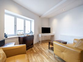 A living room with a television and sofa at Seaside Cottage Escape in Paignton