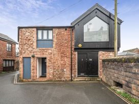 A stone building with a black door and windows at Seaside Cottage Escape in Paignton