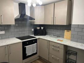 A kitchen with countertop, oven, microwave, and cabinets at Llangollen - House - Sleeps 8- Garden in Llangollen