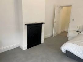 A bedroom with a fireplace and bed at Llangollen - House - Sleeps 8- Garden in Llangollen