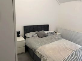 A bedroom with a bed, bedside table, lamp and radiator at Llangollen - House - Sleeps 8- Garden, Llangollen