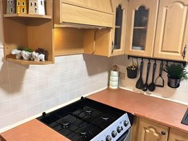 A kitchen with a stove and wooden cabinets at Llanarmon-yn-Ial Mold 3-Bed Caravan, Sleeps 6 Llanarmon-Yn-Ial