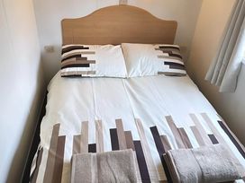 A bed with pillows and towels in a bedroom at Llanarmon-yn-Ial Mold 3-Bed Caravan, Sleeps 6 Llanarmon-Yn-Ial