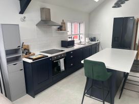 A kitchen with appliances and seating at Modern Seaside Cottage - Sleeps 5 in Paignton