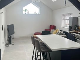 A living room with a television and bar stools at Modern Seaside Cottage - Sleeps 5, Paignton