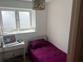A bedroom with a bed and a desk with a laptop at Modern Seaside Cottage - Sleeps 5, Paignton