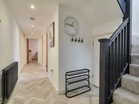 A hallway with a staircase and coat hooks at Modern Seaside Cottage - Sleeps 5 in Paignton