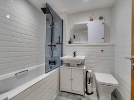 A bathroom with a bathtub, shower, sink, and toilet at Modern Seaside Cottage - Sleeps 5 in Paignton