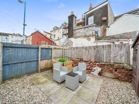 A garden with seating and a planter at Modern Seaside Cottage - Sleeps 5 in Paignton