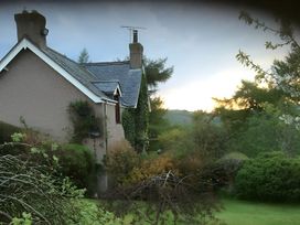 A house with garden and trees at Converted Stone Barn -20 Acres - Farm Animals! Corwen