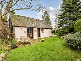 A garden with a house, pathway, and plants at Converted Stone Barn -20 Acres - Farm Animals! Corwen