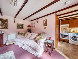 A living room with a sofa and kitchen area at Converted Stone Barn -20 Acres - Farm Animals! Corwen