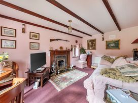 A living room with a fireplace and a television at Converted Stone Barn -20 Acres - Farm Animals! in Corwen