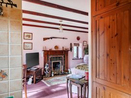 A living room with a fireplace and furniture at Converted Stone Barn -20 Acres - Farm Animals! in Corwen