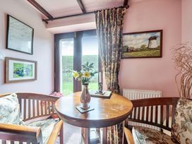 A snug area with a table and chairs at Converted Stone Barn -20 Acres - Farm Animals! in Corwen
