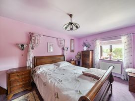 A bedroom with a bed and nightstand at Converted Stone Barn -20 Acres - Farm Animals! in Corwen