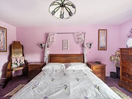 A bedroom with a bed and nightstand at Converted Stone Barn -20 Acres - Farm Animals! Corwen