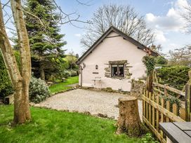 A house with gravel path and trees at Converted Stone Barn -20 Acres - Farm Animals! in Corwen